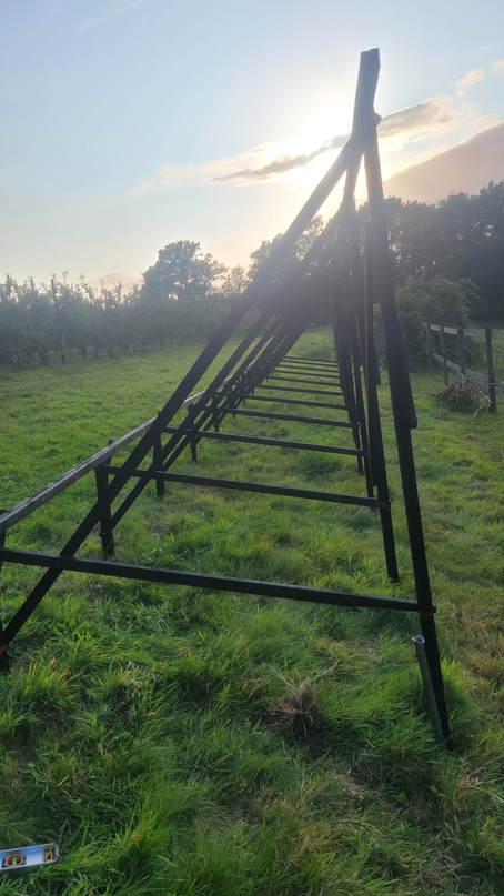Bare steel A-frame mounting structure at sunset, panels not yet fitted