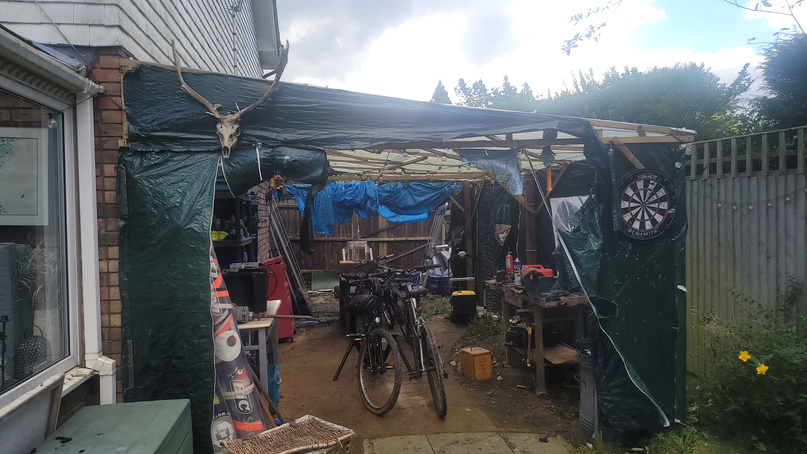 The lean-to workshop I built onto the side of the house &mdash; covered in tarpaulin, kit inside