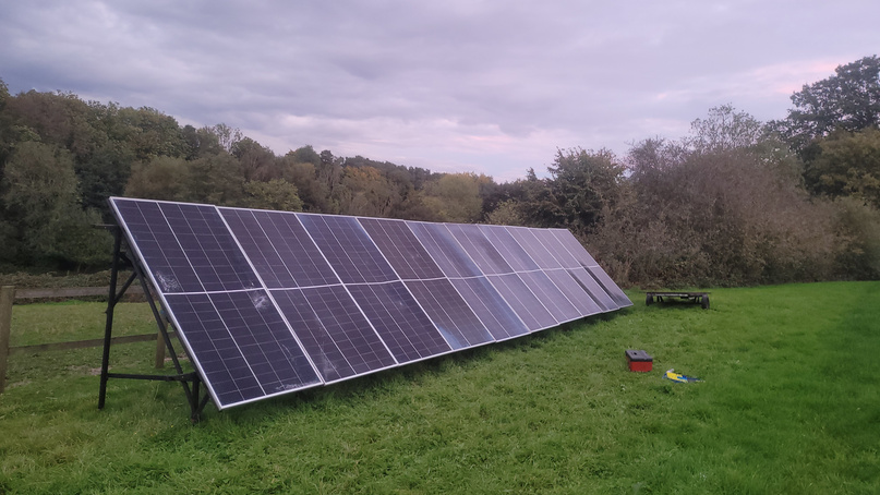 Finished ground-mount solar array in a field at sunset
